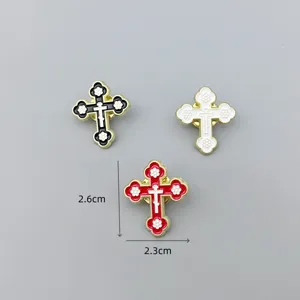 Detail shot of metal cross enamel brooch with floral design, fashion clothing accessory pin.