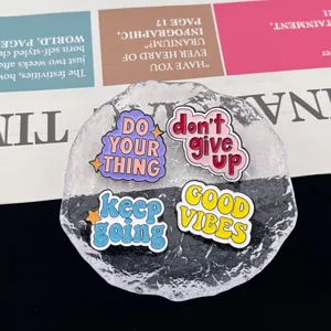 Detailed close-up of motivational enamel pins featuring vibrant English quote designs.