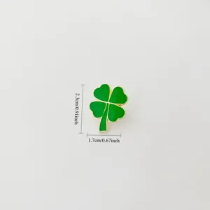 Close-up detail view of green enamel four-leaf clover brooch with gold trim design.