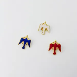 Detail view of colorful enamel dove cross brooch pins, elegant fashion apparel accessories.