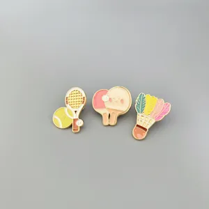 Detailed close up of cute sports themed enamel pins including tennis, table tennis and badminton.