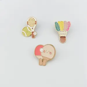 Close-up detail of cute kawaii sports enamel pins featuring tennis, badminton and ping pong.