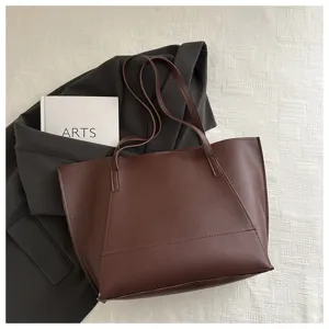 Vista di dettaglio della borsa tote in pelle marrone scuro con design minimalista.