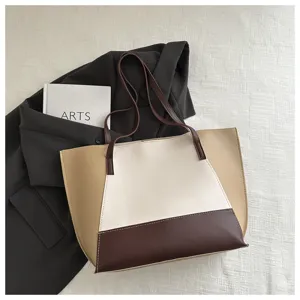 Dettaglio ravvicinato della borsa a tracolla tote color block in eleganti toni beige e marrone.