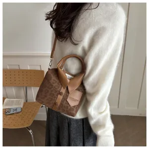 Detalle del bolso cruzado de mujer con estampado de leopardo en forma de camisa y cuello creativo.