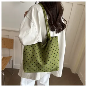 Dettaglio della borsa tote in tela a pois verdi, che mette in risalto lo stile quotidiano.