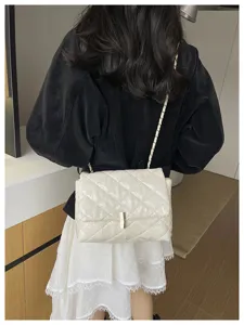 Dettaglio elegante borsa a tracolla trapuntata, catena raffinata e design chic per ogni giorno.