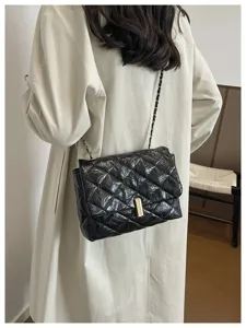 Borsa a tracolla nera matelasse in vernice con catena elegante e chiusura chic.