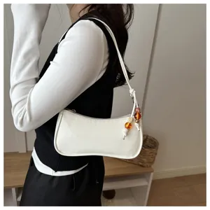 Minimalist white underarm shoulder bag with colorful beaded charm detail for women.