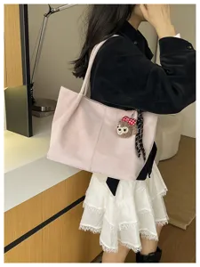 Detailansicht der großen rosa minimalistischen PU Leder Umhängetasche mit Plüsch Anhänger.