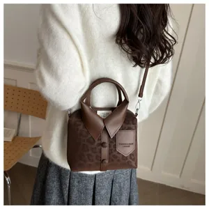 Vista detallada del bolso de mano con estampado de leopardo y cuello de camisa, textura única.