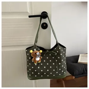 Borsa tote a pois verdi con simpatico ciondolo orsetto, elegante dettaglio a tracolla.