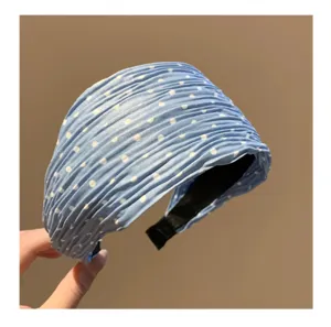 Detalle de la diadema plisada azul con lunares, banda de tela suave para uso diario.