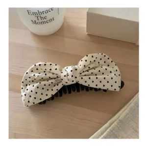 Toma detallada del lindo clip de garra para el cabello con lazo de tela y corazones.