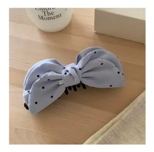 Detalle pinza pelo lazo puntos azul, accesorio para el cabello de tela elegante.
