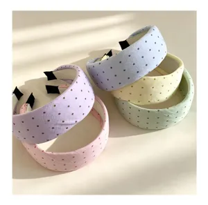 Primer plano de diademas de lunares pastel, accesorios para el cabello de tela estilo dulce.