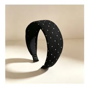 Vista detallada de la diadema ancha de punto negro con lunares y tela suave y cómoda.