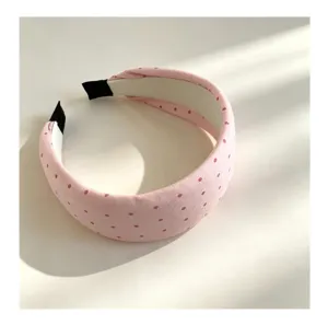 Encantadora diadema rosa con lunares, diseño dulce y minimalista para un peinado elegante.