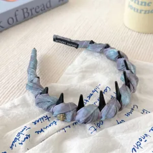 Primer plano detallado de la diadema de cuadros azules con dientes negros y tela suave.