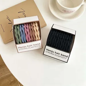 Vista detallada de gomas para el pelo elásticas y duraderas en cajas coloridas.