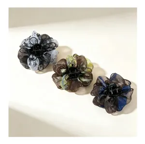 Vista detallada de elegantes pinzas de pelo de flor de malla para peinados de mujer.
