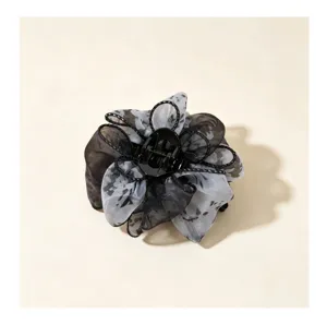 Detalle de primer plano de pinza de pelo de flor de organza negra, accesorio elegante