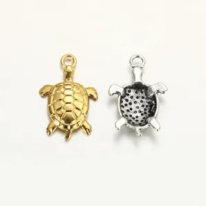 Detailed view of alloy sea turtle pendant charms, showing gold front and hollow silver back.