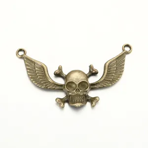 Gros plan pendentif crâne ailes bronze antique, connecteur bijoux alliage rétro.