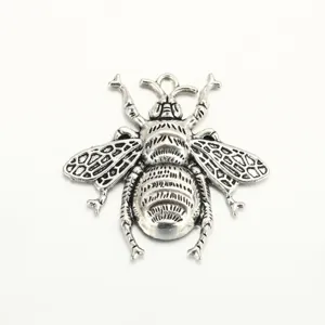 Close-up detail of a silver-toned metal insect bee pendant, perfect for DIY jewelry making.