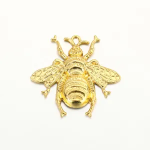 Close-up detail of the gold-colored metallic bee insect pendant, showing textured wings and body.