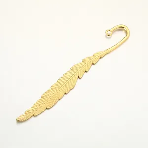 Close-up detail of vintage gold feather metal bookmark pendant, elegant DIY jewelry part.