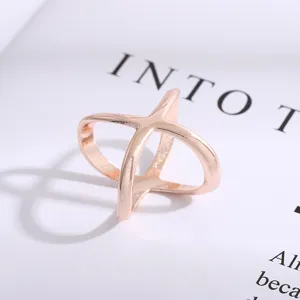 Closeup of a rose gold cross shaped scarf buckle with smooth metal surface texture detail.