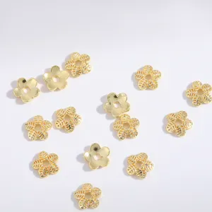 Close-up of gold flower spacer beads, hollow alloy charms for DIY jewelry making and crafts.