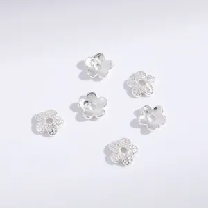 Detail view of silver alloy flower shaped bead spacers for DIY jewelry making and crafts.