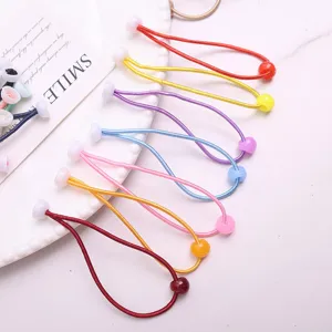 Primo piano di elastici per capelli colorati con perline per acconciature da bambina.
