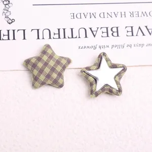 Detailed view of vintage plaid fabric five-pointed star button patch, DIY coat accessory.