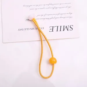 Dettaglio dell'elastico per capelli giallo con perline colorate per accessori di acconciatura.