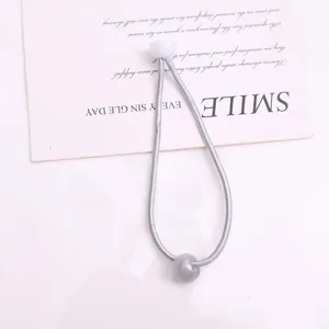 Elastico per capelli grigio con tappo bianco e perla, accessorio quotidiano minimalista.