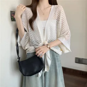 Detailed view of women's casual white hollow knit cardigan summer sun protection cover up top.