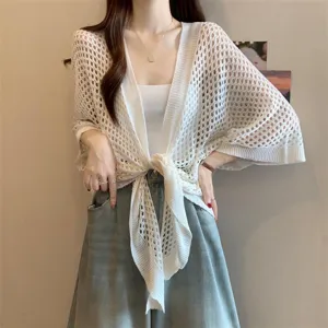 Detailed view of white hollow-out knit cardigan cape, lightweight summer women top close-up.