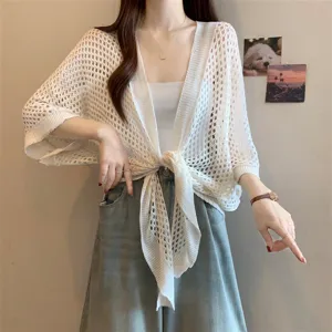 Detailed view of the white hollow-out knit cardigan showing the delicate mesh texture and front tie design.