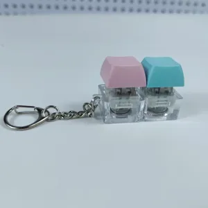 Porte-clés fidget à double interrupteur mécanique avec touches rose et bleue anti-stress.