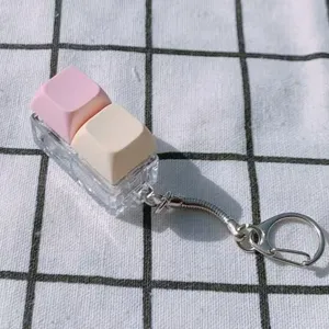 Détail de porte-clés jouet anti-stress interrupteur clavier, touches rose et beige.