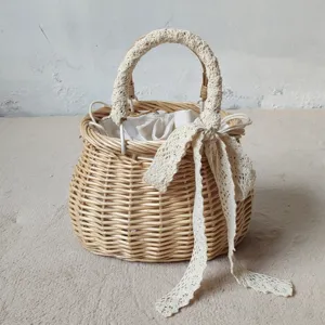 Dettaglio borsa di vimini intrecciata, manico nastro pizzo uncinetto, stile spiaggia estiva.