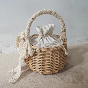 Borsa a secchiello in rattan intrecciato a mano con manico in pizzo e sacca interna.