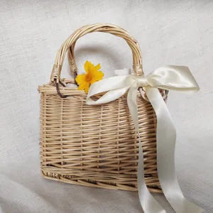 Borsa a mano in paglia intrecciata con nastro bianco e fiore giallo per vacanze estive.