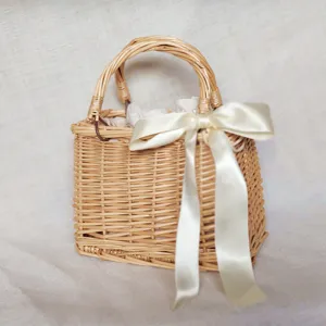 Borsa a mano in rattan intrecciato con elegante fiocco in nastro bianco per vacanze estive.
