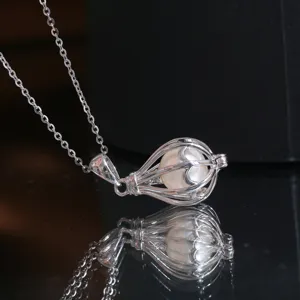 Gros plan sur les details du collier pendentif lanterne creuse en argent sterling avec perle.