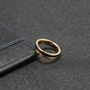 Primo piano dettagliato dell'anello in tungsteno dorato sottile con scanalatura centrale nera.