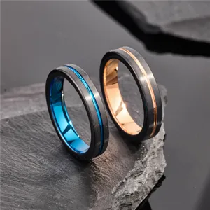 Dettaglio di fedi nuziali in acciaio al tungsteno con esterno spazzolato nero e scanalature.